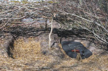 Kyiv, Ukrayna - 03 / 23 / 2022: Rusya-Ukrayna savaşı sırasında toprak savunma pozisyonunda görev yapan Ukraynalı askerler için ağaçların altındaki çukur