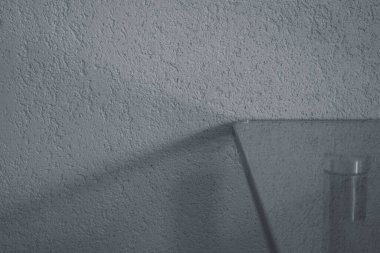 Işık duvarının arka planında cam bir masanın köşesi. Yazı için yer var. Projeniz için kalite kalıbı