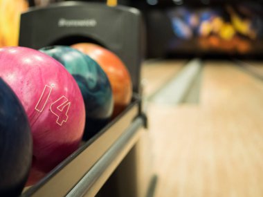 Bowling şeridi. Bowling salonundaki raflardaki birkaç bowling topunun arkaplan görüntüsü. Bowling pisti yolları