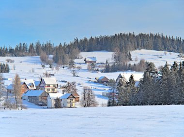 Kışın dağlık bir köy, karlı manzaralı bir panorama.