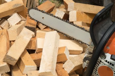 A construction worker cutting boards with a chainsaw in construction. focus on chainsaw