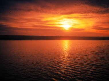 Sunset over the sea. Dramatic sundown in the sea with orange sky