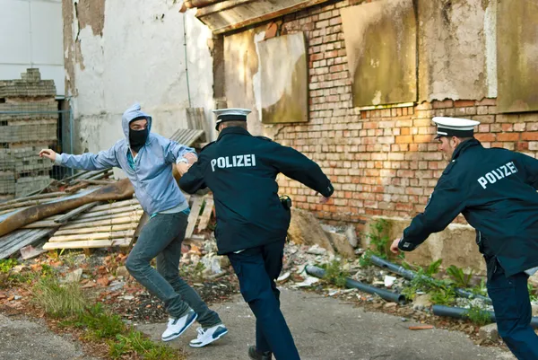 Polizisten jagen Mann lizenzfreie Stockbilder