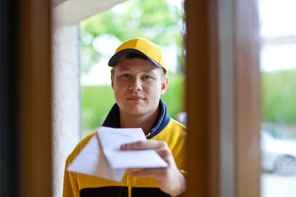 Jonge postbode in een uniform postbode — Stockfoto