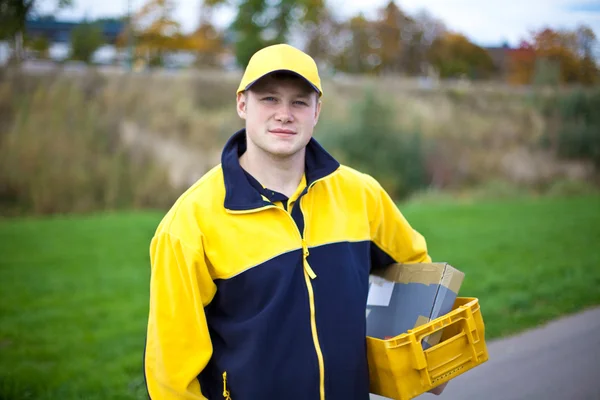 Joven cartero con uniforme de cartero Imagen de stock