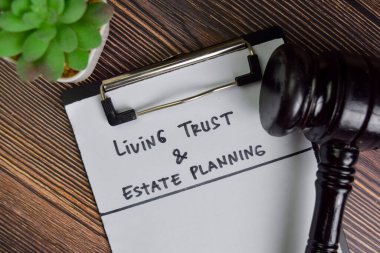 Living Trust & Estate Planlama Tahta Masa 'da izole edilmiş bir evrak üzerine yazınız.