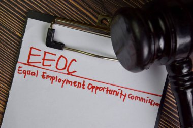 EEOC - Eşit İstihdam Fırsatı Komisyonu Tahta Masa 'da izole edilmiş bir belgeye yazı yazdı.