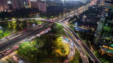 Otoyollarda ve gökdelenlerde hava manzarası. Geceleri büyük, modern bir şehrin göz kamaştırıcı gece silueti. Gürültü bulutuyla. JAKARTA - Endonezya. 25 Kasım 2021