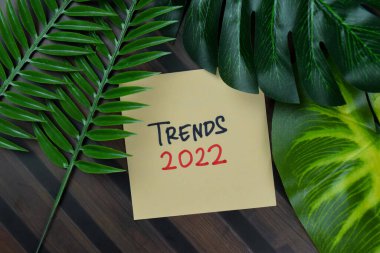 Eğilimler 2022 Tahta Masa 'da izole edilmiş yapışkan notlar üzerine yazar.
