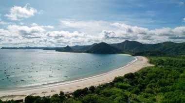 Selong Belanak 'ın hava manzarası, kumlu plajlı tropikal ada ve dalgalı turkuaz okyanus. Lombok. Endonezya, Mach 22, 2022
