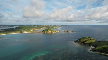 Tanjung Aan 'ın havadan görünüşü, kumlu plajlı tropikal ada ve dalgalı turkuaz okyanus. Lombok. Endonezya, Mach 22, 2022