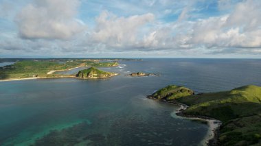 Tanjung Aan 'ın havadan görünüşü, kumlu plajlı tropikal ada ve dalgalı turkuaz okyanus. Lombok. Endonezya, Mach 22, 2022