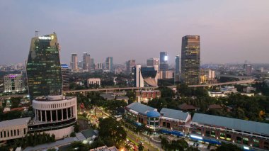Jakarta merkez iş bölgesindeki ofis binalarının hava manzarası ve gün batımında gürültü bulutu. JAKARTA, İNDONEZYA - 21 Nisan 2022