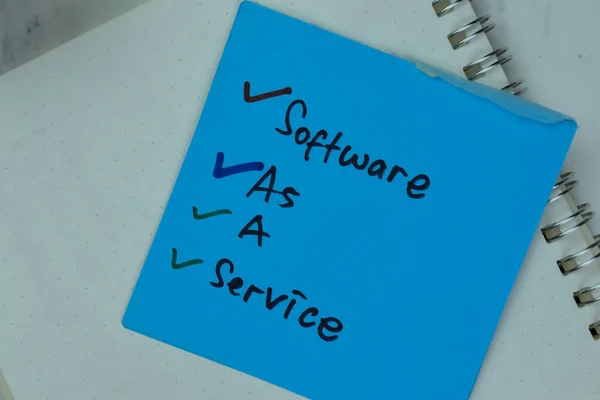 Software As A Service write on sticky notes isolated on Wooden Table.