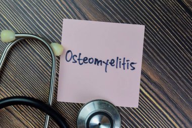 Osteomyelitis kavramı Tahta Masa 'ya izole edilmiş yapışkan notlar üzerine yazılır.