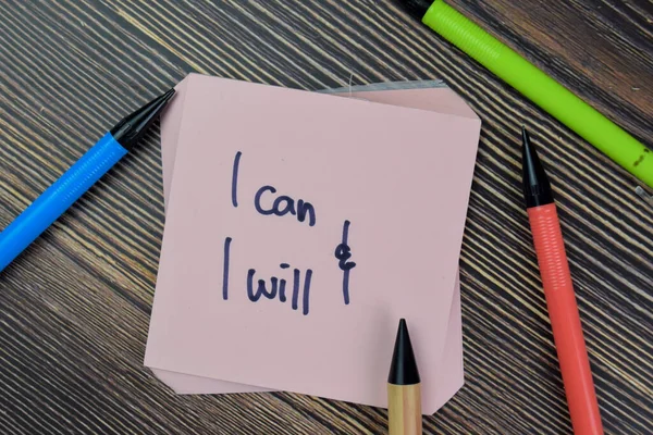 Concept of I can and I will Positive Affirmation write on sticky notes isolated on Wooden Table.