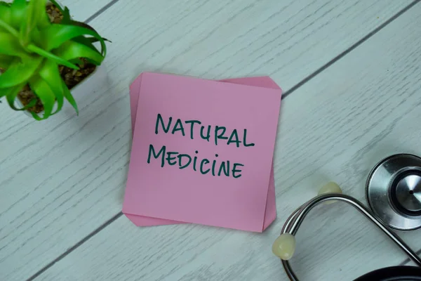 Concept of Natural Medicine write on sticky notes isolated on Wooden Table.