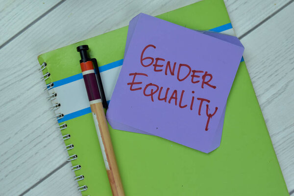 Concept of Gender Equality write on sticky notes isolated on Wooden Table.