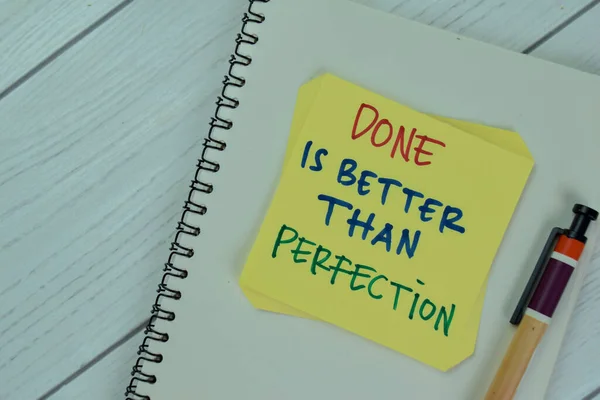 Concept of Done is Better Than Perfection write on sticky notes isolated on Wooden Table.