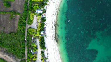 Tanjung Aan 'ın havadan görünüşü, kumlu plajlı tropikal ada ve dalgalı turkuaz okyanus. Lombok. Endonezya, 11 Temmuz 2022