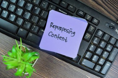 Concept of Repurposing Content write on sticky notes isolated on Wooden Table.