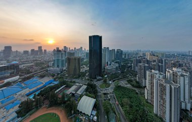 Jakarta merkez iş bölgesindeki ofis binalarının hava manzarası ve gün batımında gürültü bulutu. Jakarta, Endonezya, 1 Ağustos 2022