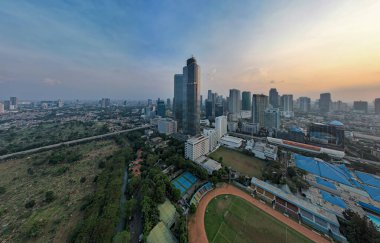 Jakarta merkez iş bölgesindeki ofis binalarının hava manzarası ve gün batımında gürültü bulutu. Jakarta, Endonezya, 1 Ağustos 2022