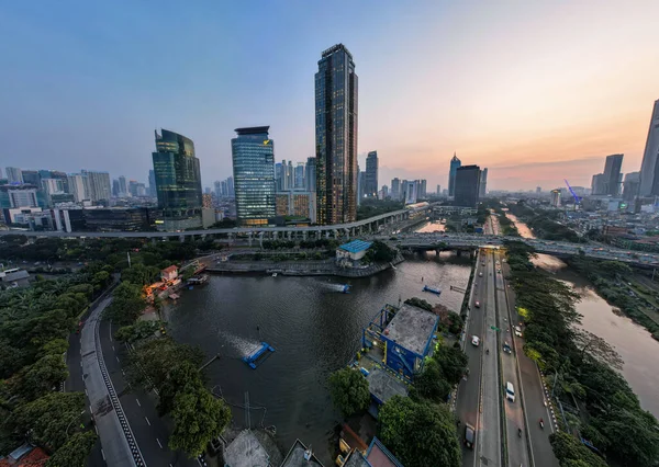 Jakarta merkez iş bölgesindeki ofis binalarının hava manzarası ve gün batımında gürültü bulutu. Jakarta, Endonezya, 1 Ağustos 2022