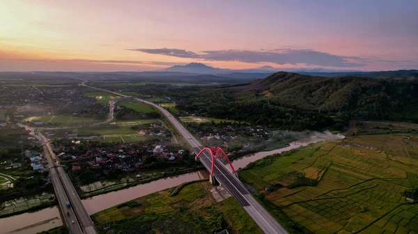 Aerial view of the Kalikuto Bridge, an Iconic Red Bridge at Trans Java Toll Road, Batang when sunrise. Central Java, Indonesia, August 24, 2022