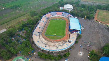 Aerial view of the Beautiful scenery of Kanjuruhan Stadium. with Malang cityscape background. Malang, Indonesia, August 26, 2022