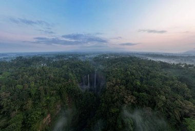 Aerial view of Tumpak Sewu waterfall and Semeru mountain at sunrise located in Lumajang. East Java, Indonesia, August 28, 2022