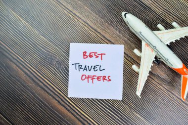 Concept of Best Travel Offers write on sticky notes isolated on Wooden Table.