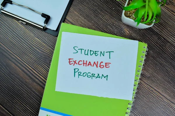 Concept of Student Exchange Program write on sticky notes isolated on Wooden Table.