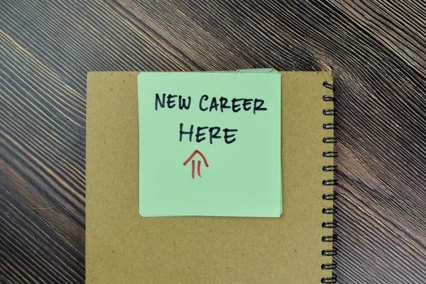 Concept of New Career Here write on sticky notes isolated on Wooden Table.