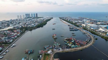 Pluit Limanı 'nın Parlak Pınar şehir manzarasının havadan görüntüsü. Jakarta, Endonezya 'nın renkli günbatımı manzarası. Güzel Cakarta deniz manzarası. Seyahat konsepti geçmişi. Jakarta, Endonezya, 16 Eylül 2022