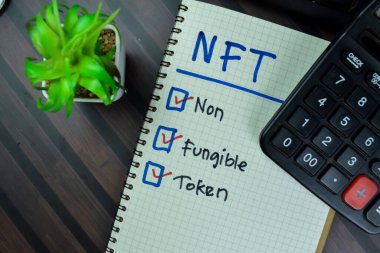 NFT kavramı - Parasız Token Tahta Masa 'da izole edilmiş bir kitaba yazın.