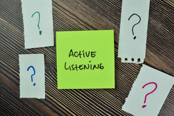Concept of Active Listening write on sticky notes isolated on Wooden Table.