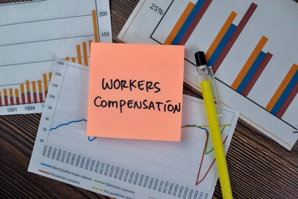 Concept of Workers Compensation write on sticky notes isolated on Wooden Table.