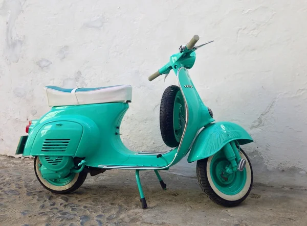 Green Vespa standing on the street 스톡 사진