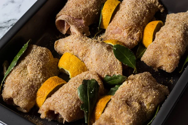 Tütsülenmiş scamorza peynirli tavuk dürümleri ve pişirilmiş jambon ve ekmek kırıntıları. Saha yaprağı ve limon dilimleriyle pişirilmiş.