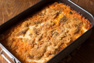 Ahşap zemin üzerinde pişirme kabında vejetaryen pilavı.