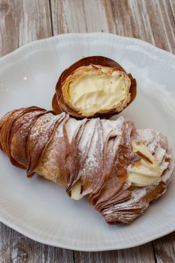 Beyaz servis tabağında kremalı ıstakoz kuyruğu. İtalyan pastası. Tahta arka planda beyaz fırça darbeleriyle izole edilmiş.