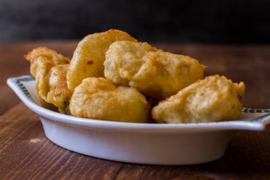 Kızarmış morina, ahşap arka planda servis edilen tabakta servis edilir.