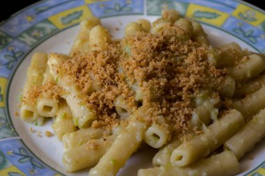 Organik Romanesco brokoli soslu makarna ve siyah ahşap arka planda kızarmış ekmek kırıntıları serpiştirilmiş.