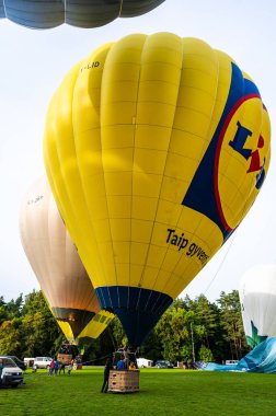 Vilnius, Litvanya - 14 Eylül 2021: Yer personeli Litvanya 'nın Vilnius kentindeki Vingis parkında kalkış için renkli bir sıcak hava balonu hazırlayın.