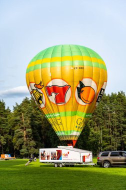 Vilnius, Litvanya - 14 Eylül 2021: Yer personeli Litvanya 'nın Vilnius kentindeki Vingis parkında kalkış için renkli bir sıcak hava balonu hazırlayın.