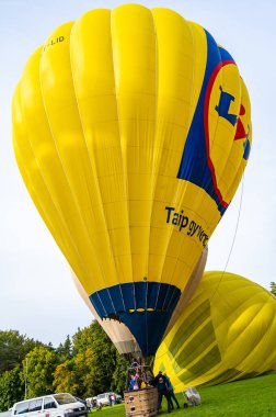 Vilnius, Litvanya - 14 Eylül 2021: Yer personeli Litvanya 'nın Vilnius kentindeki Vingis parkında kalkış için sarı sıcak hava balonu hazırlayın.