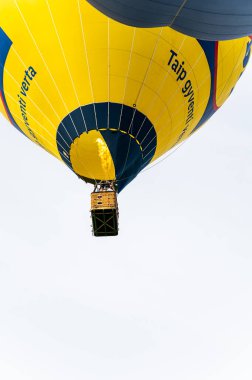 Vilnius, Litvanya - 14 Eylül 2021: Bir grup yolcuyla birlikte Litvanya 'nın Vilnius şehrinde havalanan canlı sarı sıcak hava balonu.