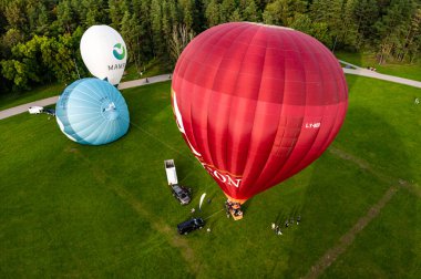 Vilnius, Litvanya - 14 Eylül 2021: Litvanya 'nın Vilnius kentindeki Vingis parkından tek tek ayrılan renkli sıcak hava balonları grubu.
