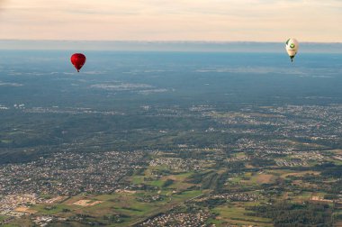 Vilnius, Litvanya - 14 Eylül 2021: Beyaz ve kırmızı sıcak hava balonları Litvanya 'nın başkenti Vilnius üzerinde uçuyor. Gökyüzünden Vilnius şehir manzarası